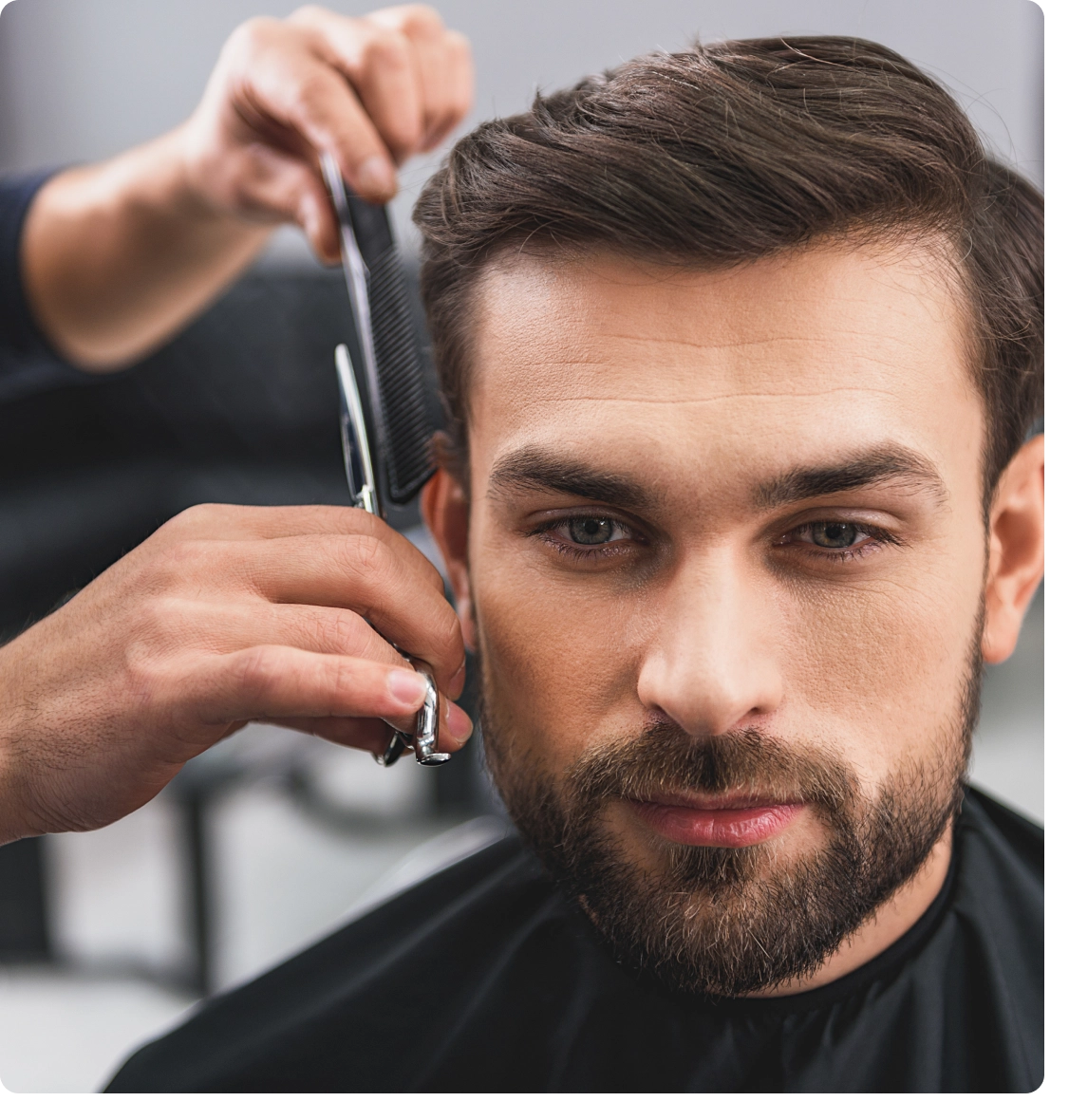 A man getting his hair cut by another person