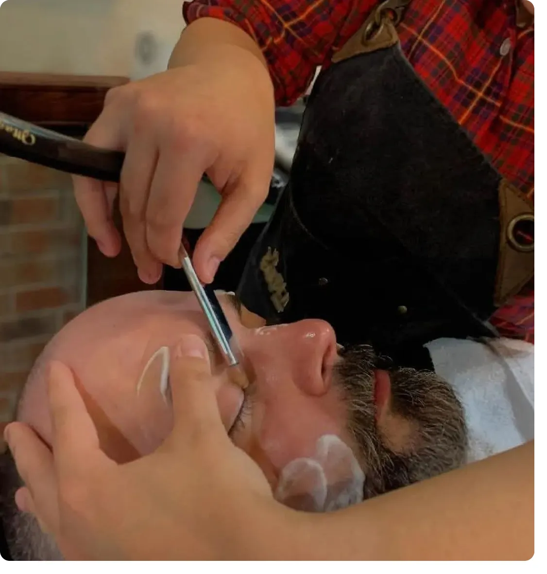 A man getting his hair cut by another person.